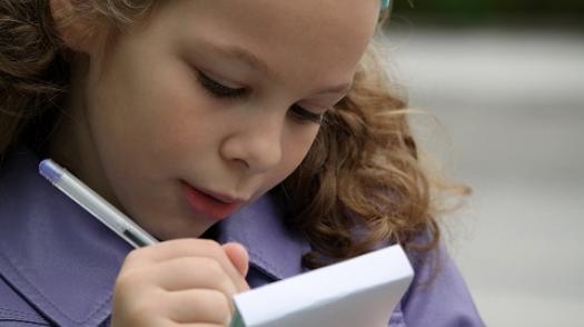Child writing in notepad